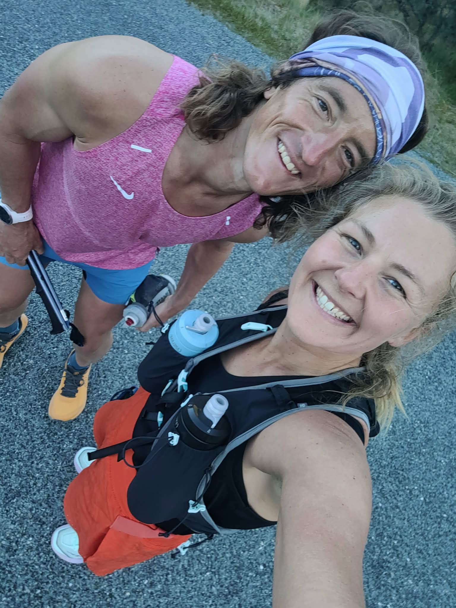 Brooke and a running partner smiling on an early morning run, packs on, sweaty and happy